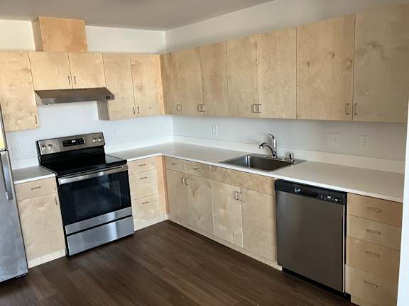 Floor Plan  A kitchen with wooden cabinets and a stainless steel dishwasher.