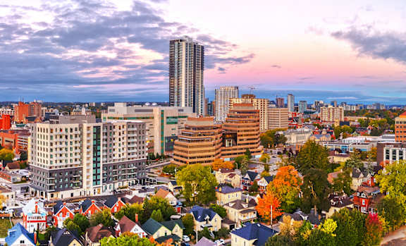 A cityscape with a mix of residential and commercial buildings under a sky with scattered clouds.