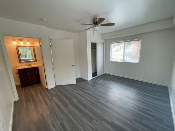 Floor Plan  an empty living room with wooden floors and a ceiling fan