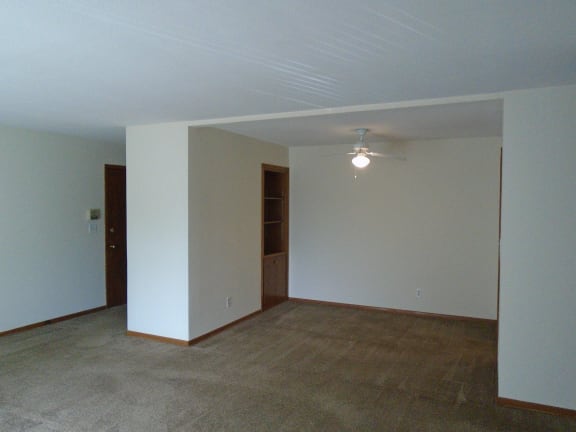 Floor Plan  an empty living room with white walls and a ceiling fan