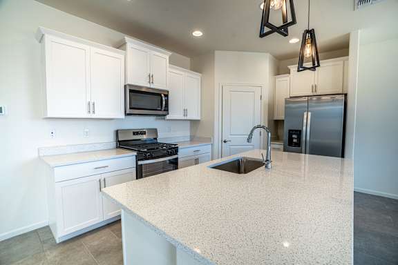 Floor Plan  A kitchen with white cabinets, stainless steel appliances, and granite counter tops.