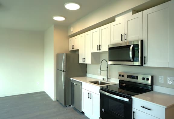 Floor Plan  A kitchen with white cabinets and black appliances.