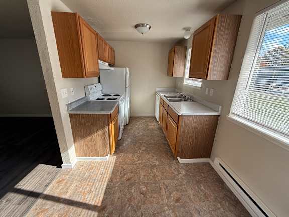 Floor Plan  A kitchen with wooden cabinets and a white refrigerator.
