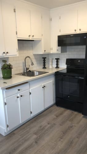 Floor Plan  a kitchen with white cabinets and black appliances
