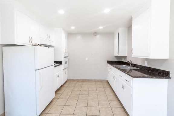 Floor Plan  a white kitchen with white appliances and white cabinets