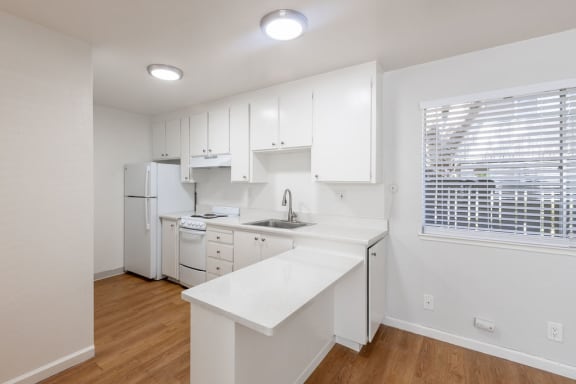 Floor Plan  a white kitchen with white cabinets and a window