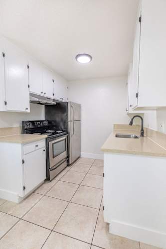 Floor Plan  a kitchen with white cabinets and a sink and a stove