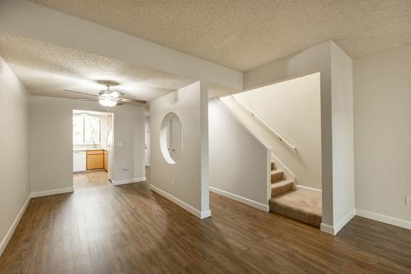 Floor Plan  an empty living room with hard wood floors and a staircase