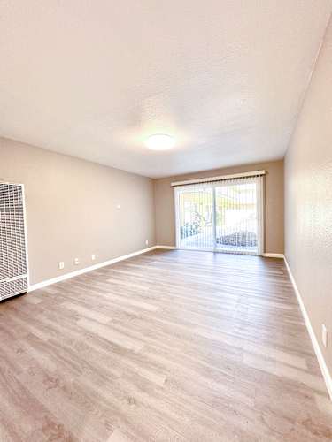 Floor Plan  an empty living room with hardwood flooring and a sliding glass door