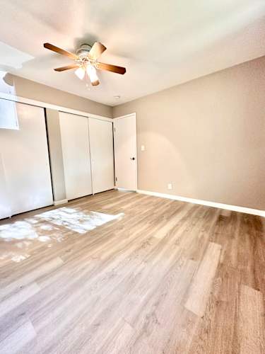 Floor Plan  an empty living room with wood flooring and a ceiling fan