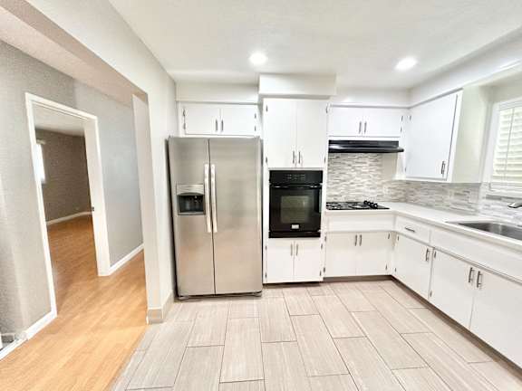 Floor Plan  A kitchen with a refrigerator, oven, and sink.