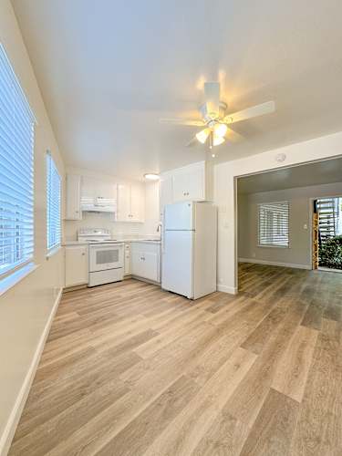 Floor Plan  A kitchen with white appliances and wooden floors.