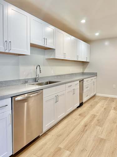 Floor Plan  A kitchen with white cabinets and a stainless steel dishwasher.