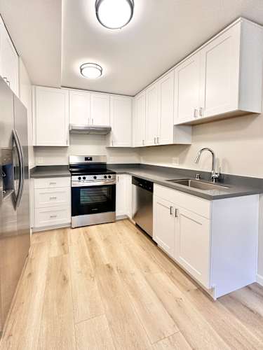 Floor Plan  A modern kitchen with white cabinets and a wooden floor.