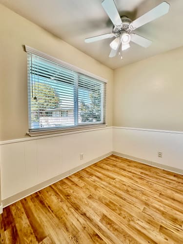 Floor Plan  an empty bedroom with a large window and a ceiling fan