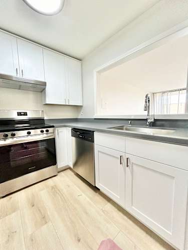 Floor Plan  A kitchen with white cabinets and a stainless steel dishwasher.