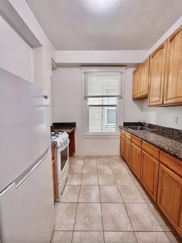 Floor Plan  a kitchen with wooden cabinets and a white refrigerator
