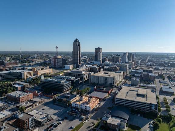 A cityscape with a mix of modern and older buildings under a clear sky.