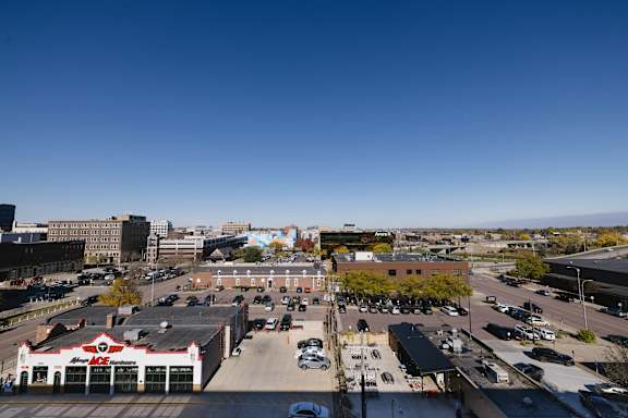 A parking lot with cars and a building with a red roof.