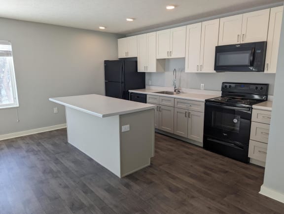 Floor Plan  a kitchen with white cabinets and black appliances