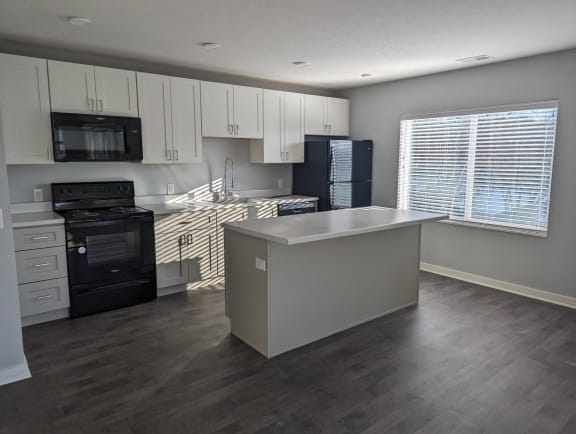 Floor Plan  a kitchen with white cabinets and black appliances and a white counter top