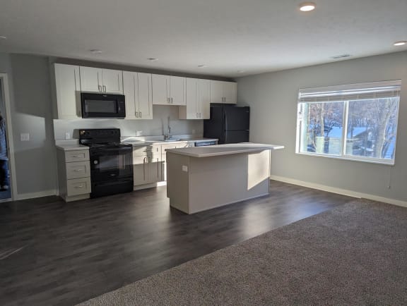 Floor Plan  an empty kitchen with white cabinets and black appliances