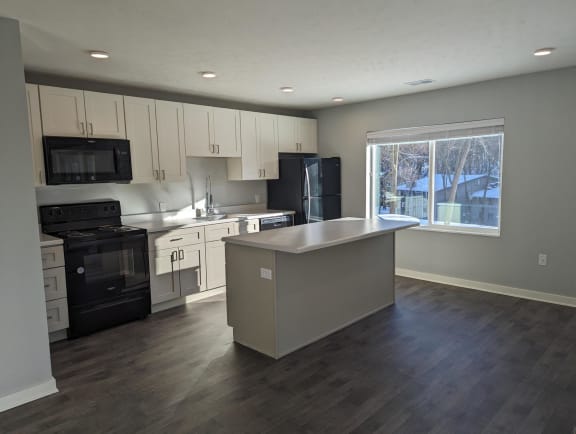 Floor Plan  an empty kitchen with white cabinets and black appliances