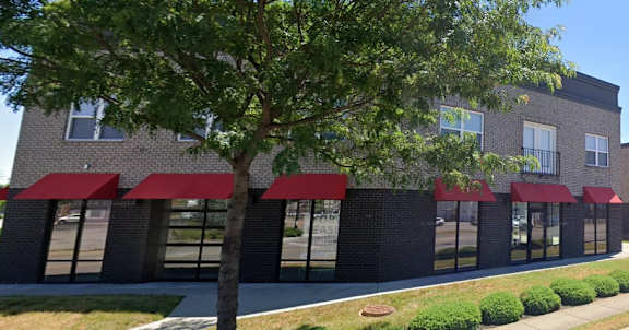 Floor Plan  A building with red awnings and a tree in front.