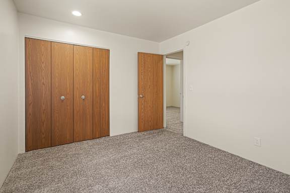 Floor Plan  A room with two brown doors and a carpeted floor.