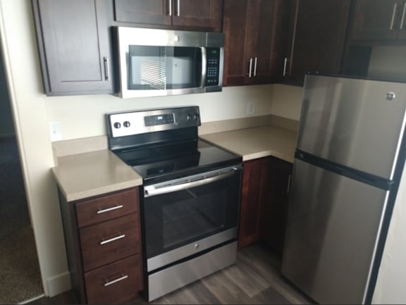 Floor Plan  A kitchen with a stainless steel refrigerator, oven, and microwave.