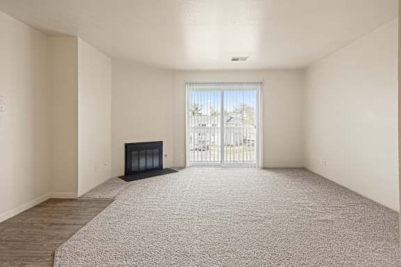 Floor Plan  A large, empty room with a fireplace and a carpeted floor.