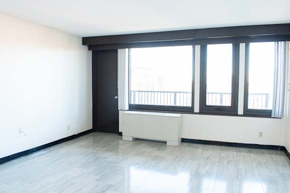 Floor Plan  A large empty room with a window seat and a door.