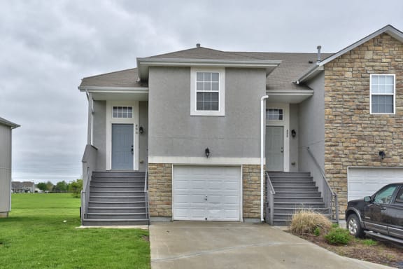 Floor Plan  a gray house with a car parked in a driveway
