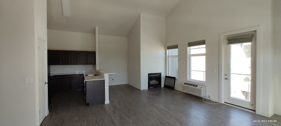Floor Plan  an empty living room with a kitchen in the background