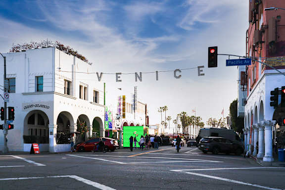 A street view of a city with the word "VENICE" written in the sky.