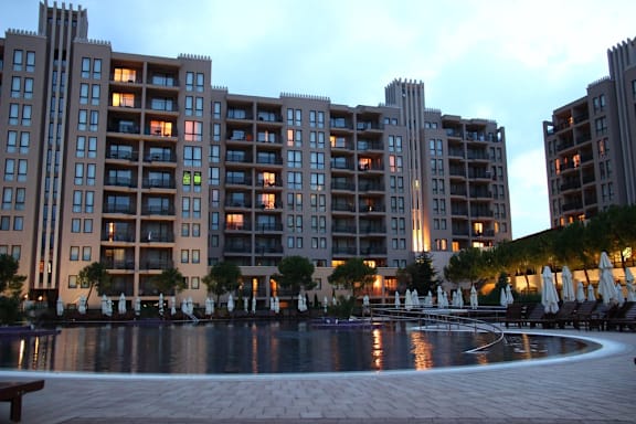 A large building with a pool in front of it.