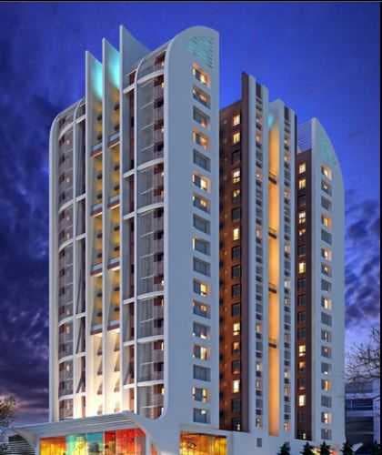 A modern white building with a lot of windows and balconies.
