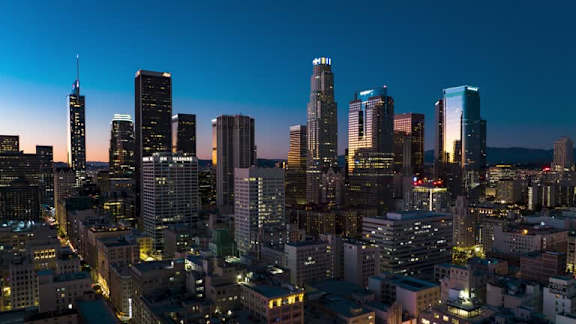 A city skyline at night with tall buildings and lights.