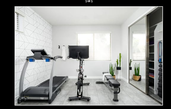 Floor Plan  A home gym with a treadmill, rowing machine, and bench press.