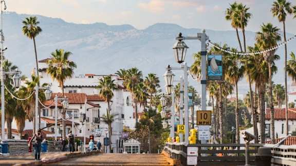 A street scene with palm trees and a sign that reads "10 MPH".