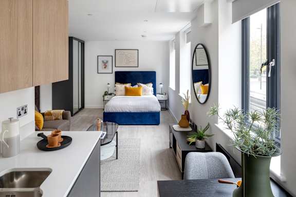 Floor Plan  A modern bedroom with a bed, a chair, a table, and a mirror.