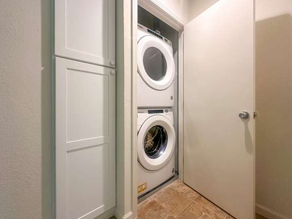 A white washing machine and dryer in a small laundry room.