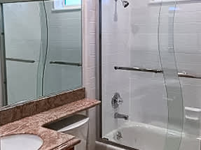 A bathroom with a sink, toilet, and shower.