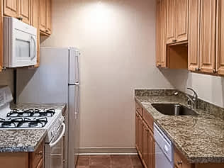 A kitchen with a granite counter top and a sink.