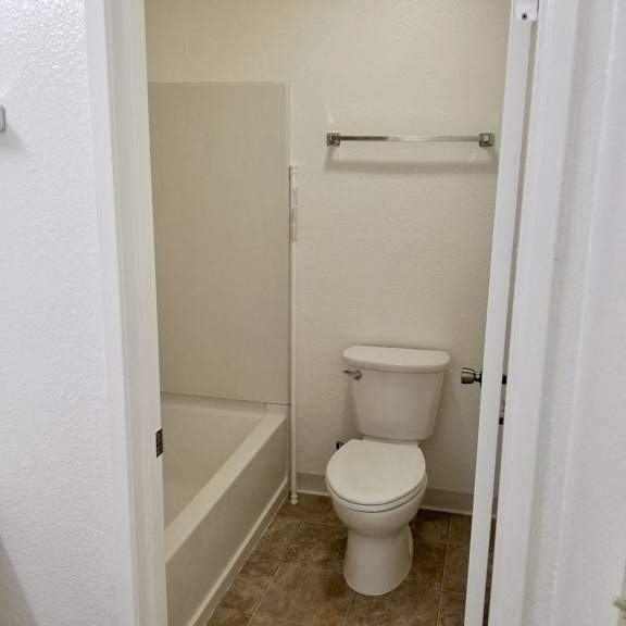 A white toilet in a small bathroom.