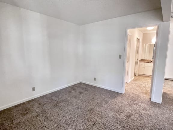 a bedroom with white walls and carpet