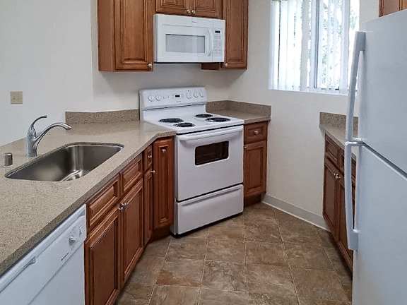 A kitchen with a white stove and a white refrigerator.
