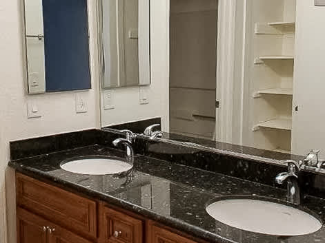 A bathroom with two sinks and a mirror.