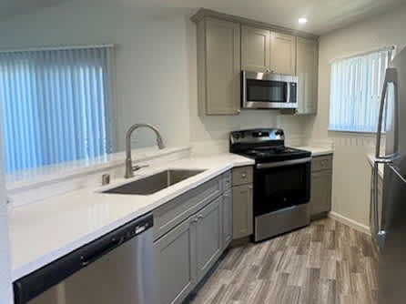 A kitchen with a stove, oven, and microwave.
