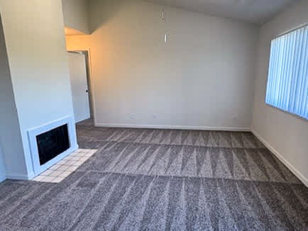 A room with a fireplace and carpeted floor.